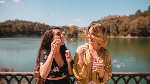 Smiling women blowing bubbles