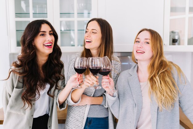 Smiling women clinking glasses