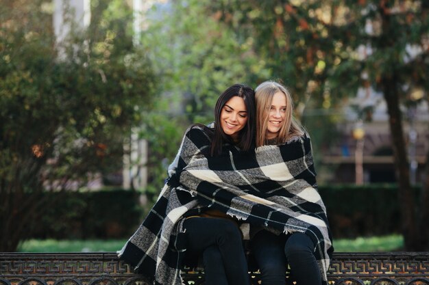 Smiling women embracing in plaid