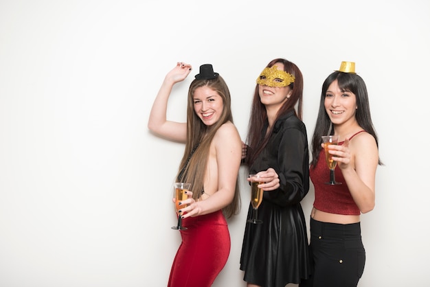 Smiling women in evening wear with glasses of drinks