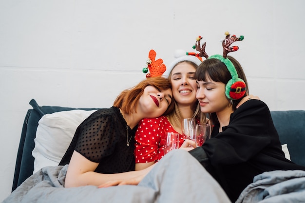 Smiling women holding wine glasses and enjoying pajamas party