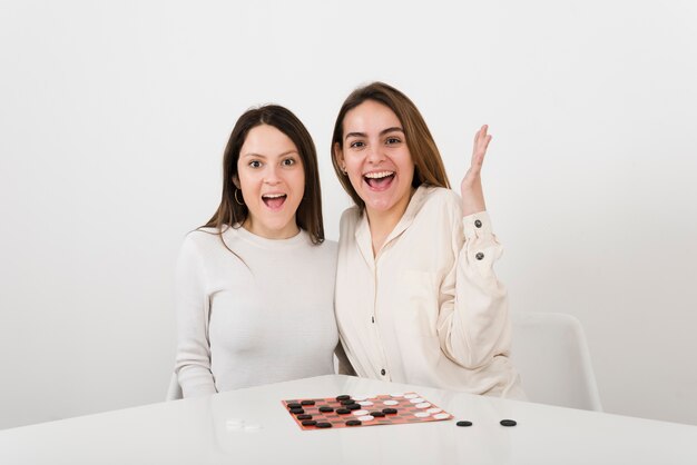 Smiling women playing checkers