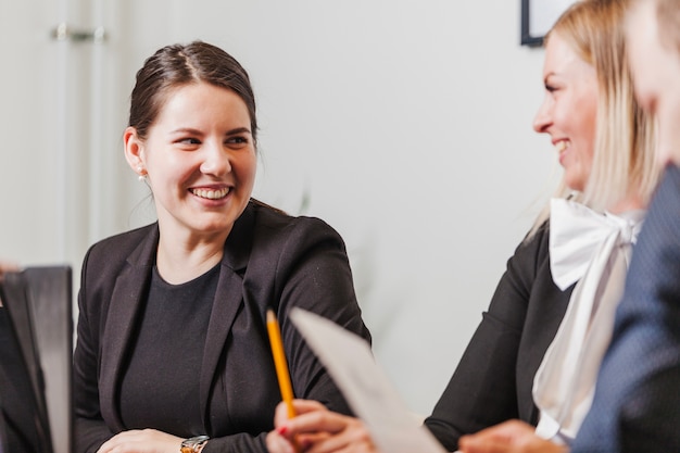 Smiling women in suits sitting smiling