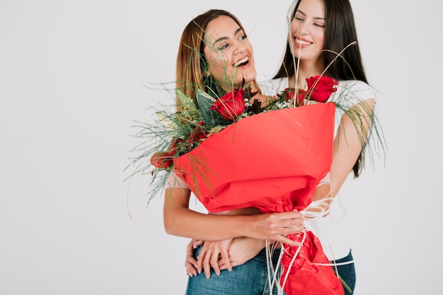 Free photo smiling women with bouquet in studio