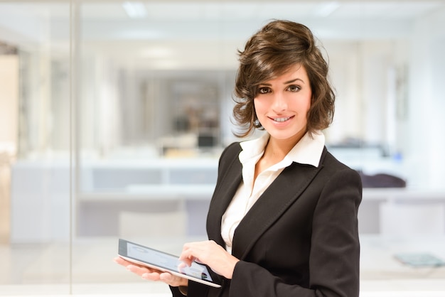 Free photo smiling worker with the tablet at the office