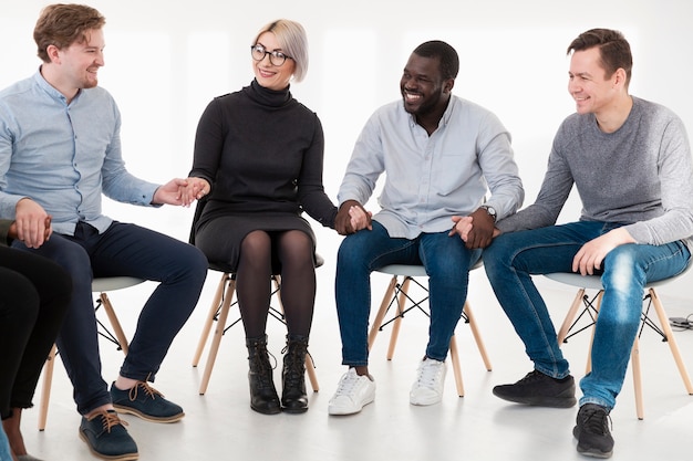 Free photo smiling young adults holding each other hands