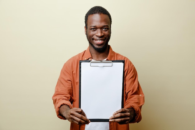 Sorridente giovane afroamericano maschio che tiene appunti isolato su sfondo bianco