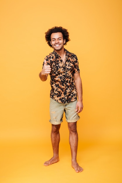 Smiling young african man with thumbs up.