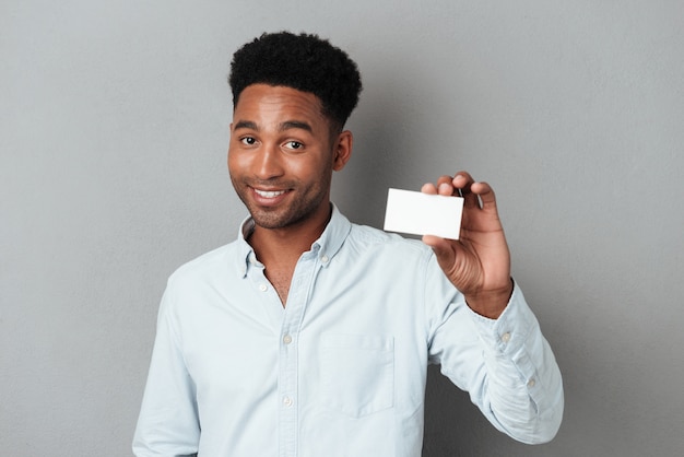 Free photo smiling young afro american guy holding blank business card