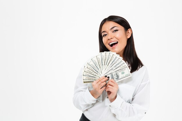 돈을 들고 웃는 젊은 아시아 여자.
