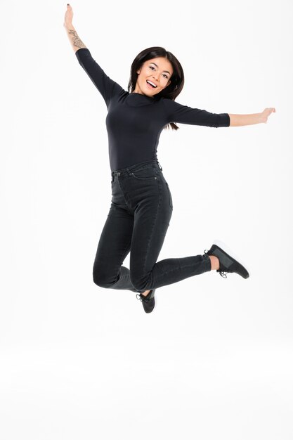 Smiling young asian woman jumping