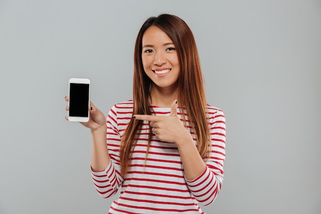 電話の表示を示す笑顔の若いアジア女性