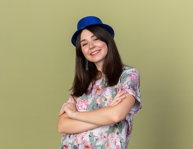 Smiling young beautiful girl wearing party hat crossing hands 