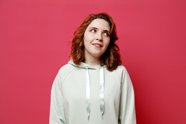 Free photo smiling young beautiful girl in white sweater isolated on pink background