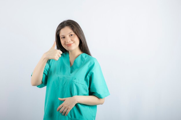 親指を立てて笑顔の若い美しい看護師