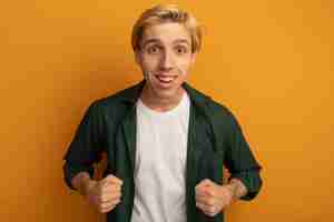 Free photo smiling young blonde guy wearing green t-shirt showing yes gesture