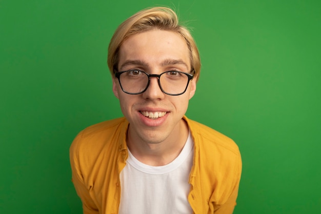 Smiling young blonde guy wearing yellow t-shirt and glasses