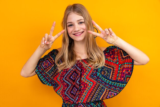 Smiling young blonde slavic girl gesturing victory sign 