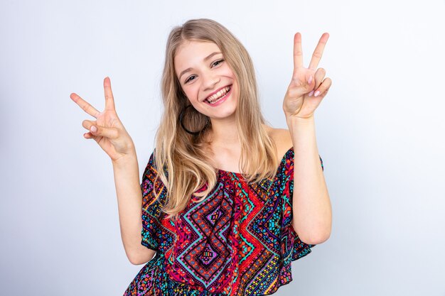 Smiling young blonde woman gesturing victory sign 