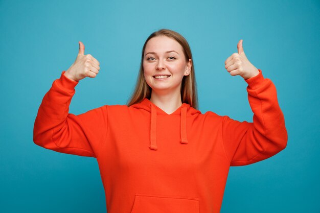 親指を立てて笑顔の若いブロンドの女性