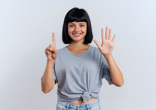 Free photo smiling young brunette caucasian girl gestures six with fingers looking