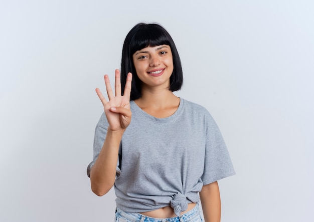 Smiling young brunette caucasian woman gestures four with fingers