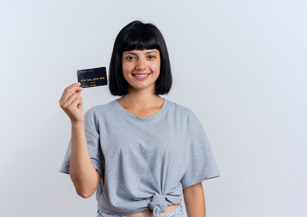 笑顔の若いブルネット白人女性はクレジットカードを保持します