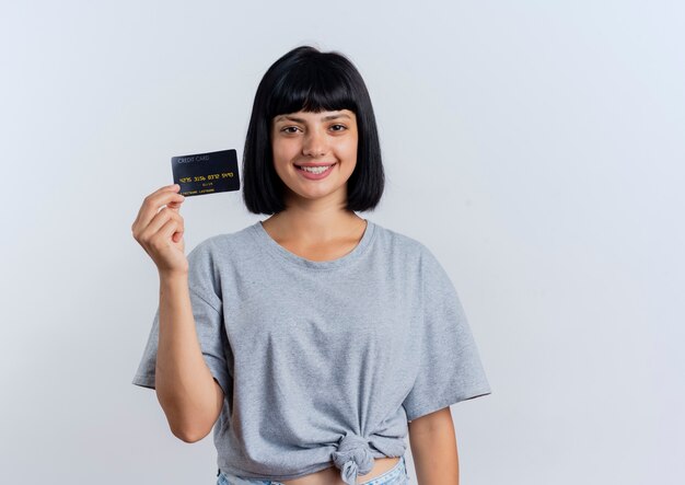 Smiling young brunette caucasian woman holds credit card