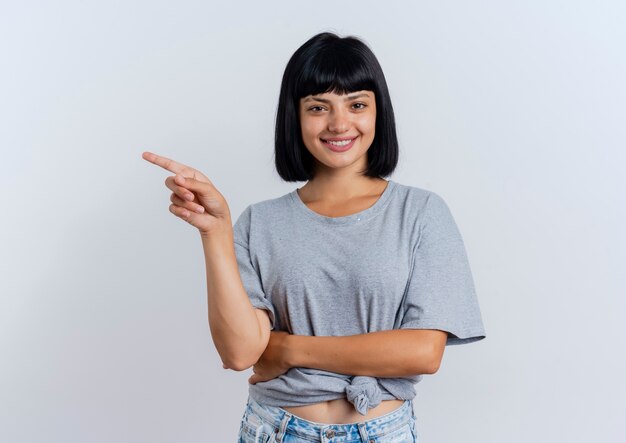 Smiling young brunette caucasian woman points at side