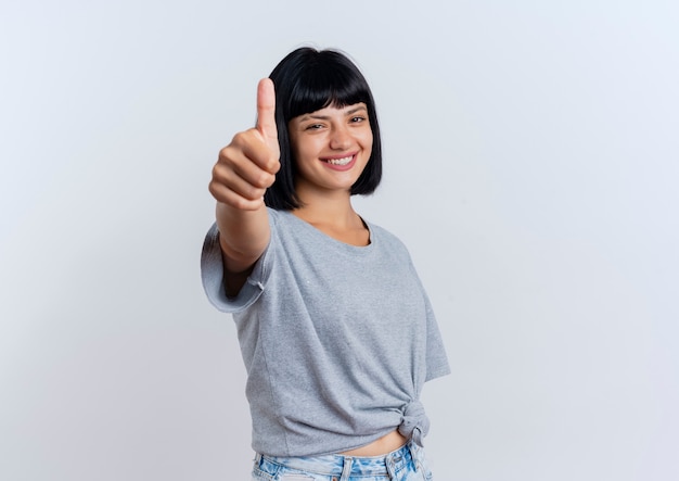 Smiling young brunette caucasian woman thumbs up