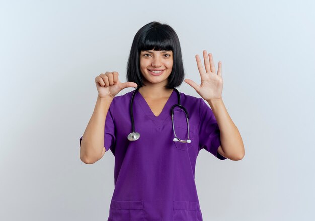 Smiling young brunette female doctor in uniform with stethoscope