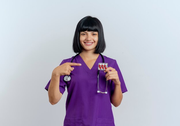 Smiling young brunette female doctor in uniform with stethoscope