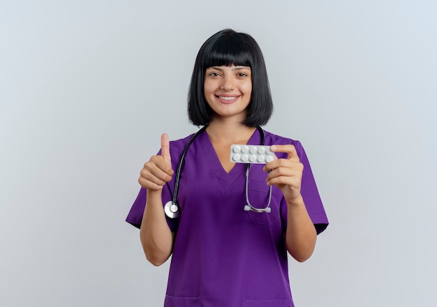 Улыбается молодая брюнетка женщина-врач в униформе со стетоскопом