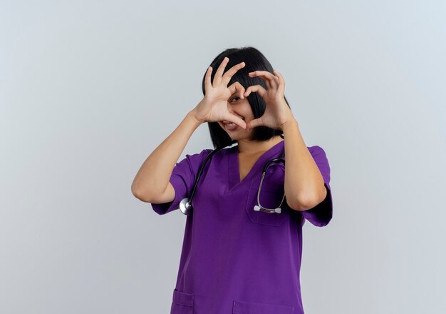 Smiling young brunette female doctor in uniform with stethoscope