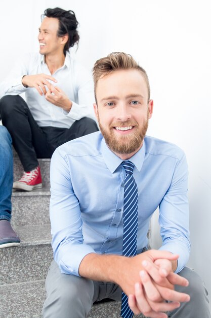 Smiling Young Business Man Sitting on Stairs