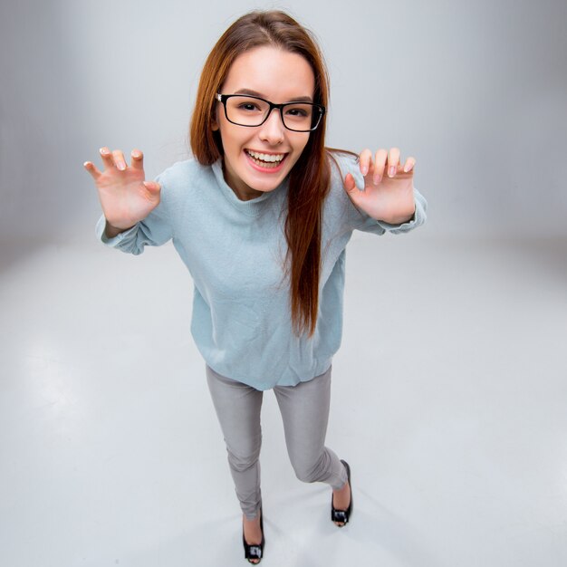 The smiling young business woman on gray wall