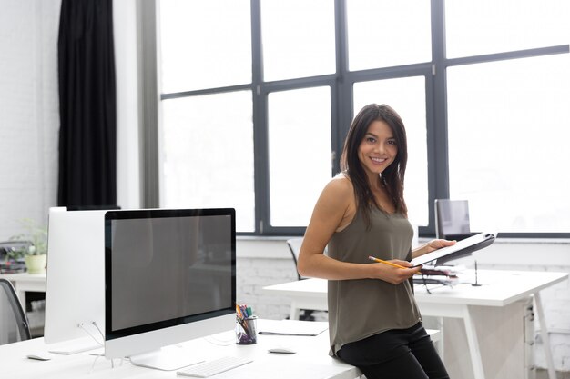 Smiling young business woman holding notepad