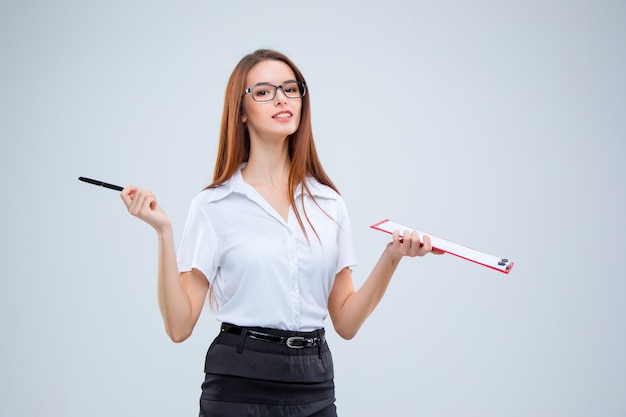 The smiling young business woman with pen and tablet for notes on gray background