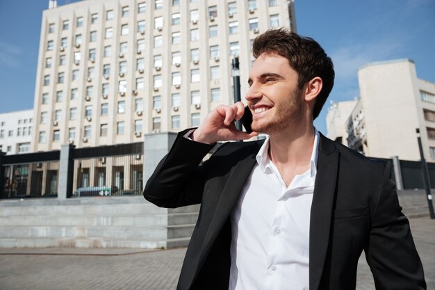 Free photo smiling young businessman walking outdoors.