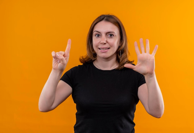 Smiling young casual woman showing one and five on isolated orange space