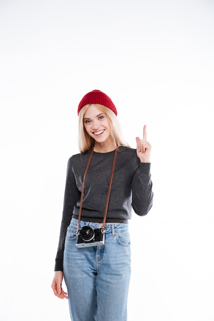 Free photo smiling young casual young woman pointing finger up