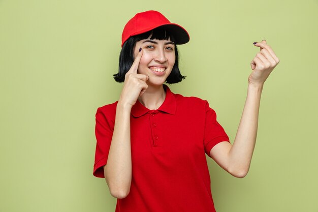 Smiling young caucasian delivery woman gesturing money 