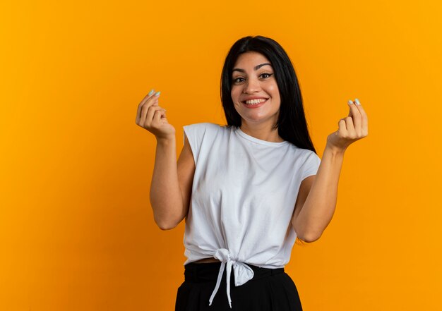 Smiling young caucasian woman gestures money hand sign