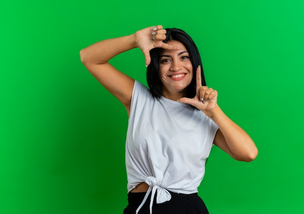 Foto gratuita sorridente giovane donna caucasica che gesturing segno cornice