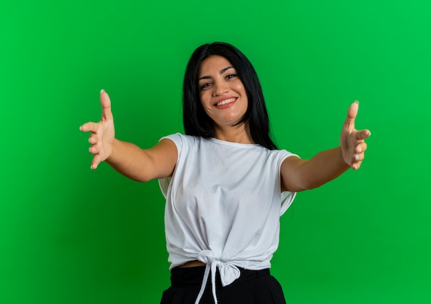 Smiling young caucasian woman holds out hands pretending to hold something