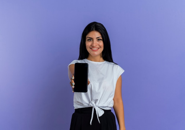 Smiling young caucasian woman holds phone