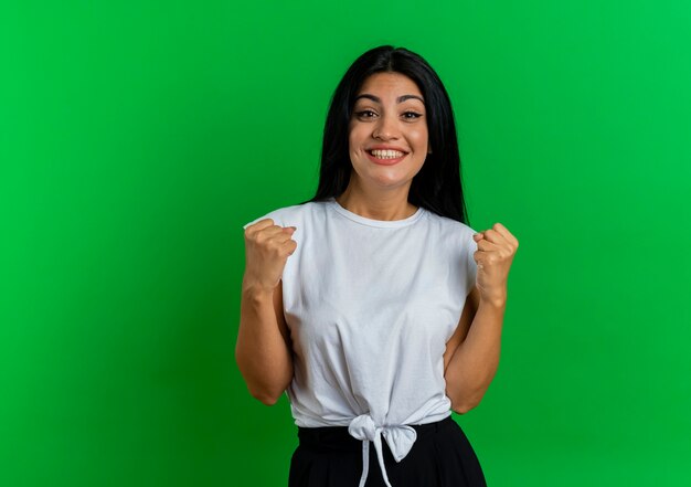 Smiling young caucasian woman keeps fists