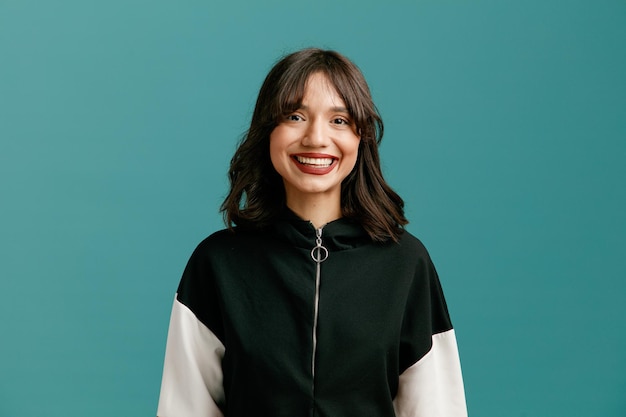 Smiling young caucasian woman looking at camera isolated on blue background