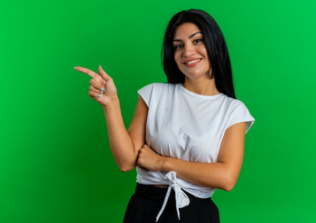 Smiling young caucasian woman points at side