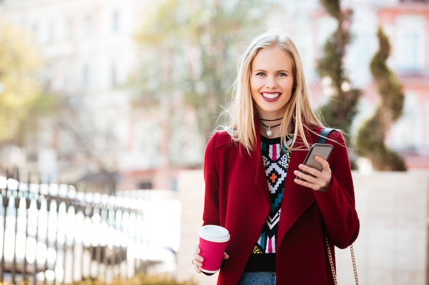 Smiling young caucasian woman walking outdoors chatting